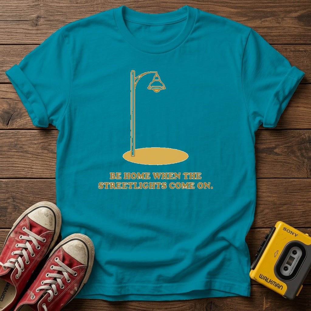 “Be Home When the Streetlights Come On”  T‑Shirt — Tropical Blue wood flat-lay