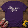 Bless Your Heart Script T-Shirt — Purple wood flat-lay