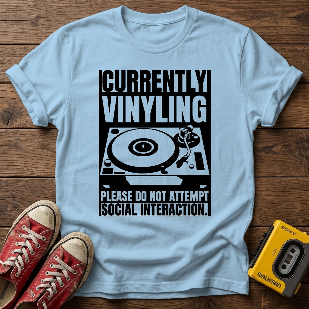 "Currently Vinyling, Please Do Not Attempt Social Interaction" T-Shirt — Light Blue wood flat-lay