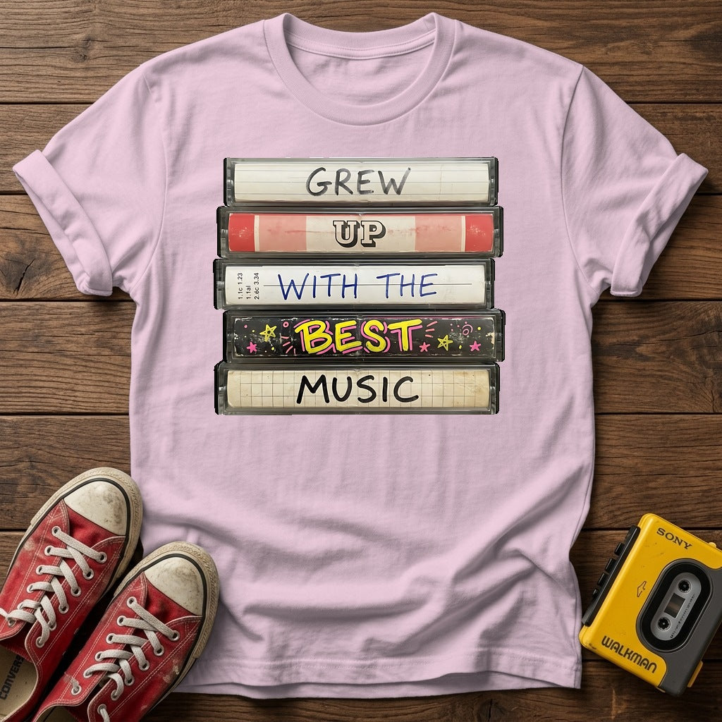"Grew Up With The Best Music" Vintage Cassette Stack T Shirt — Light Pink wood flat-lay