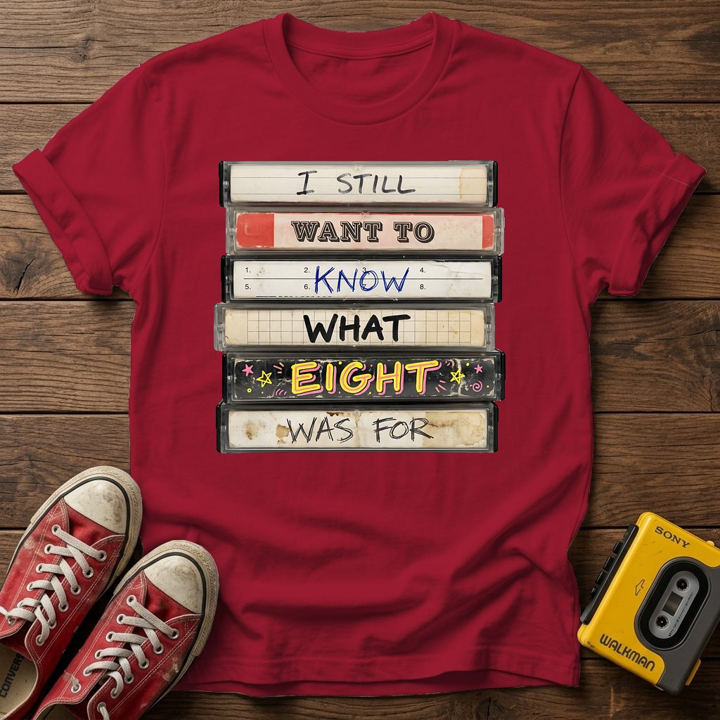 “I Still Want To Know What Eight Was For” Retro VHS Stack T Shirt — Antique Cherry Red wood flat-lay