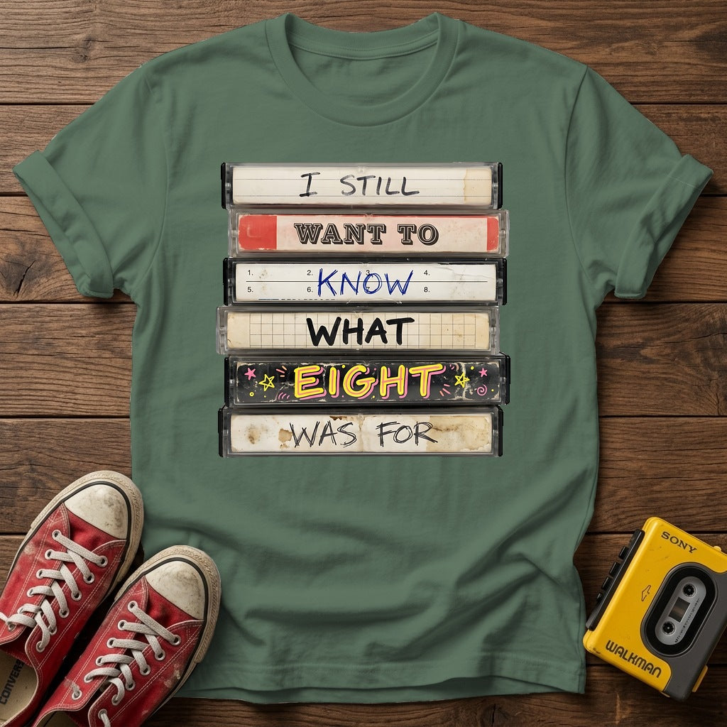 “I Still Want To Know What Eight Was For” Retro VHS Stack T Shirt — Military Green wood flat-lay
