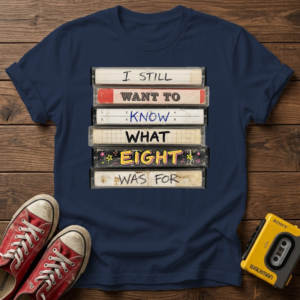 “I Still Want To Know What Eight Was For” Retro VHS Stack T Shirt — Navy wood flat-lay