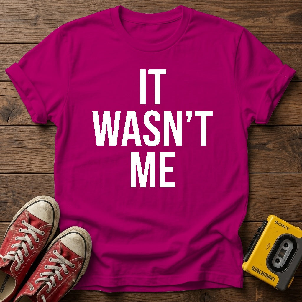 It Wasn't Me T-Shirt — Antique Heliconia wood flat-lay