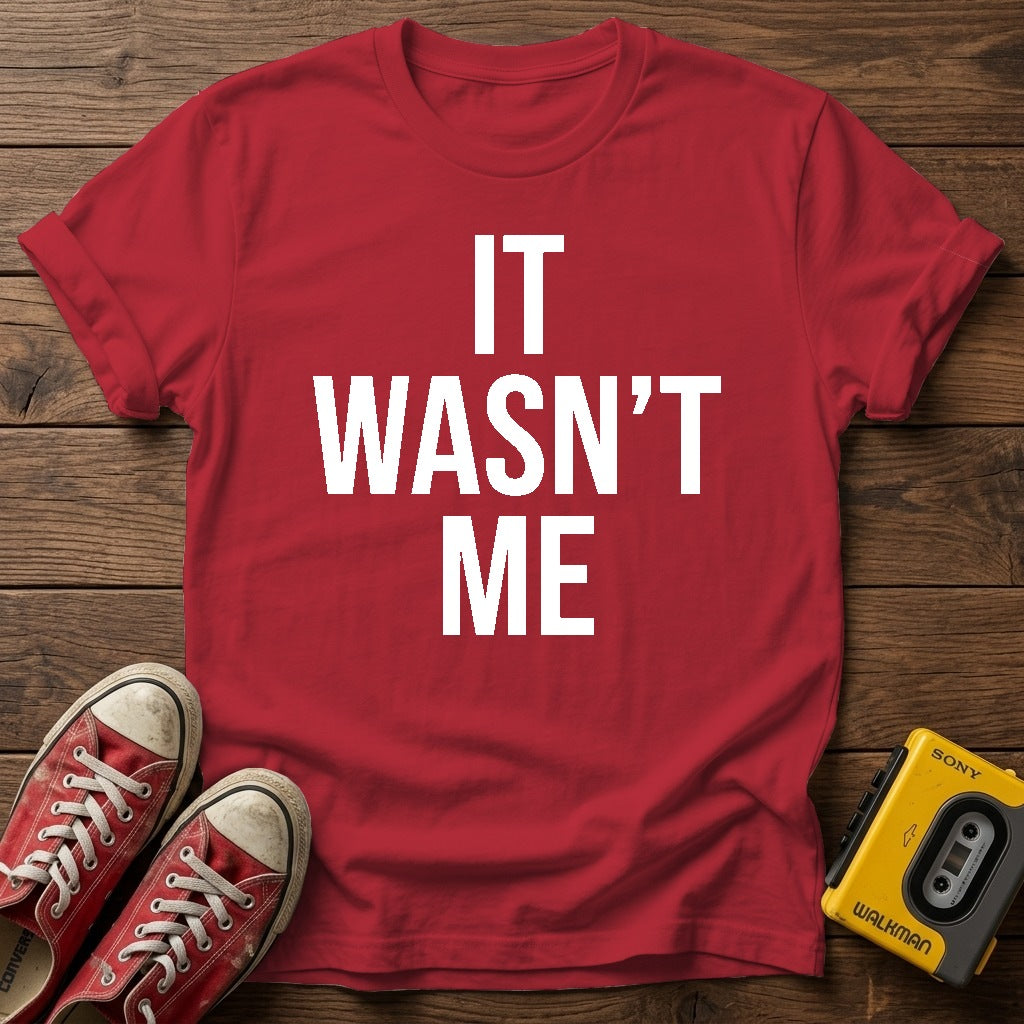 It Wasn't Me T-Shirt — Cherry Red wood flat-lay