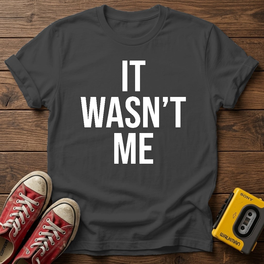 It Wasn't Me T-Shirt — Dark Heather wood flat-lay