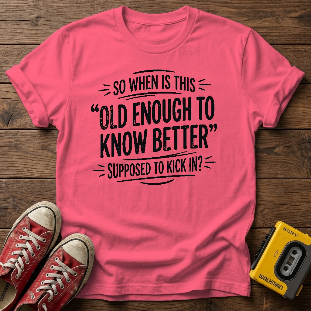 "So When Is This 'Old Enough to Know Better' Supposed to Kick In?" T Shirt — Coral Silk wood flat-lay